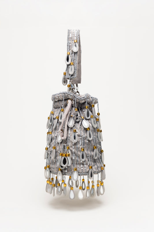 Silver Elio handcrafted bucket bag with cascading teardrop mirror glass fringe, sequin details and grey tone design