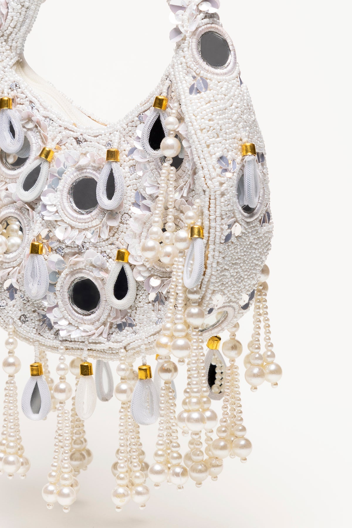 Martinas Bridal Formentera bag detail: handcrafted white beaded statement piece with pearl drops, mirror-glass details and cascading pearl fringe