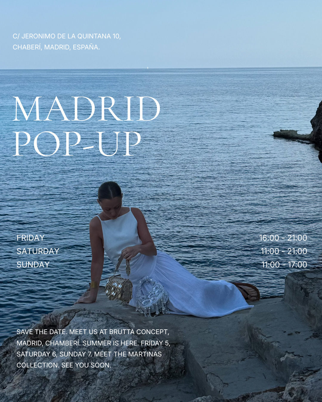 Woman in white linen dress holding beaded bag by Mediterranean sea at Madrid summer pop up event